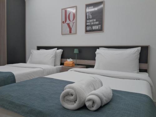 a hotel room with two beds with towels on them at Shade Suites & Studios in Beirut