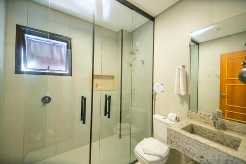 a bathroom with a glass shower and a toilet at Pousada Santa Felicidade in Campos do Jordão