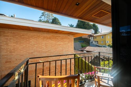 a balcony with a view of a house at Pousada Santa Felicidade in Campos do Jordão