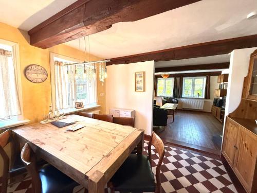 ein Esszimmer mit einem Holztisch und Stühlen in der Unterkunft Altenteil in Oldsum