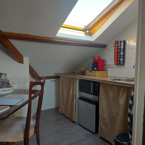 a kitchen with a table and a skylight at The Rooftop Retreat - by The M House in Arnhem