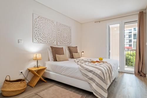 a white bedroom with a large bed and a window at Carmo Heritage Apartments in Funchal
