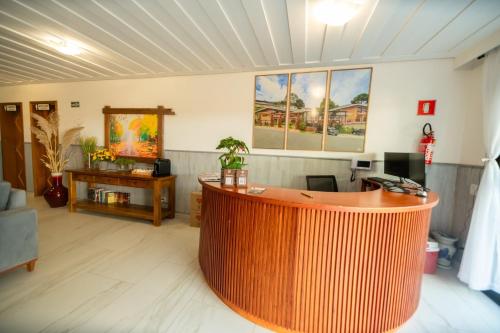 an office with a large wooden reception desk in a room at Pousada Santa Felicidade in Campos do Jordão