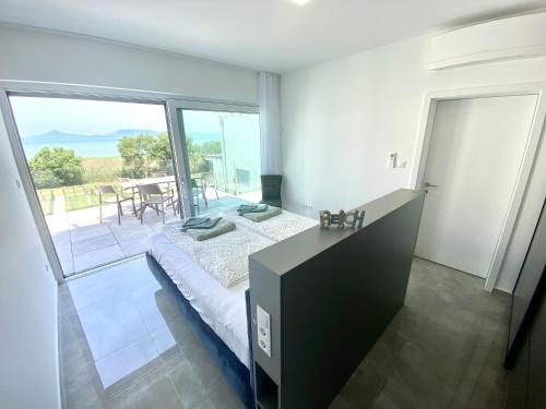 a bedroom with a bed and a large window at Villapark Apartman B2 Fonyód in Fonyód