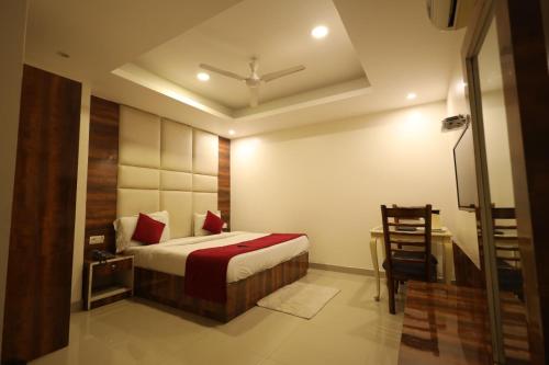 a bedroom with a bed and a table and a chair at The Paramant Near Delhi IGI Airport in New Delhi