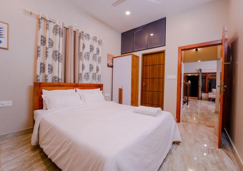 a bedroom with a large white bed in a room at Oasis Apartment with Pool in Vythiri in Vythiri