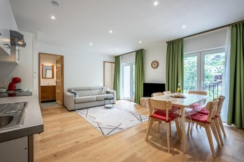 Una cocina y una sala de estar con mesa y sillas. en Villa la source, en Brides-les-Bains