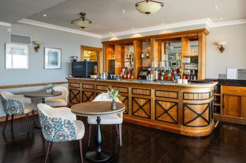 a bar in a restaurant with tables and chairs at Hotel Cristina in St Lawrence