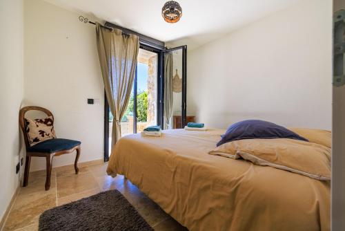 Un dormitorio con una cama y una silla y una ventana. en Le Petit Mas, en Vence