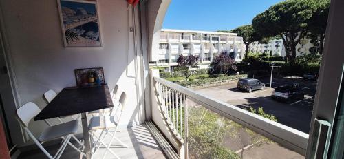 einen Balkon mit einem Tisch und Straßenblick in der Unterkunft Studio cv 4p, parking privée cosy design in La Grande-Motte