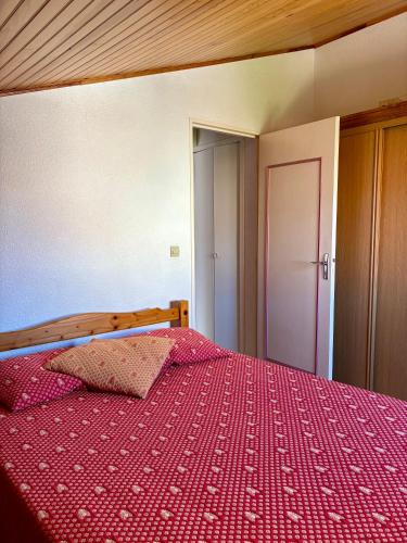une chambre avec un lit avec une couette rouge dans l'établissement Maison mitoyenne résidence Piscine proche plage 5PB157, au Barcarès