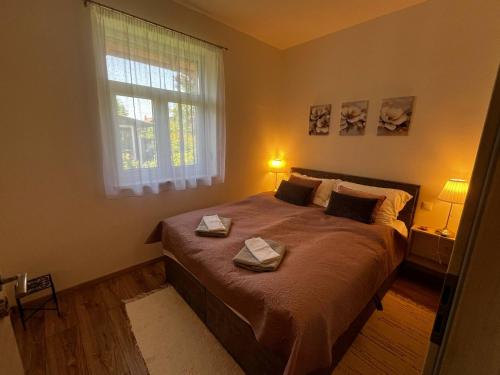 a bedroom with a bed with two towels on it at Vadvirág Vendégház Gárdony in Gárdony