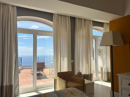 a bedroom with a large window with a view of the ocean at Hotel Della Piccola Marina in Capri
