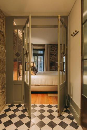 a bedroom with a bed and a checkered floor at Torel Saboaria in Porto