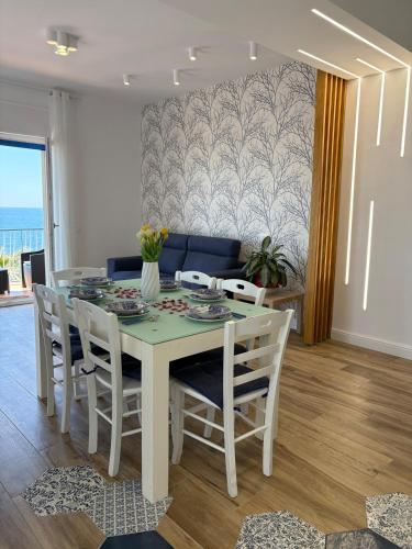 a dining room with a white table and chairs at L'Abbraccio di Parthenope in Torre del Greco