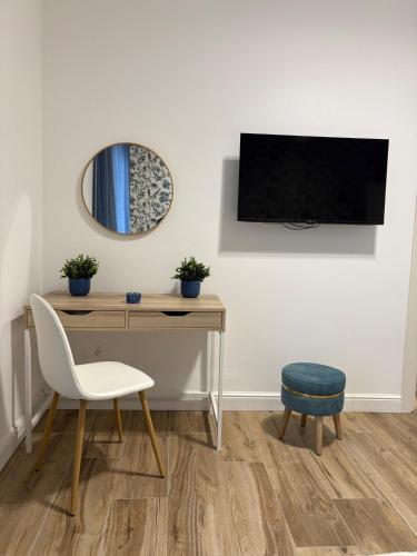 a desk with a chair and a tv on a wall at L'Abbraccio di Parthenope in Torre del Greco