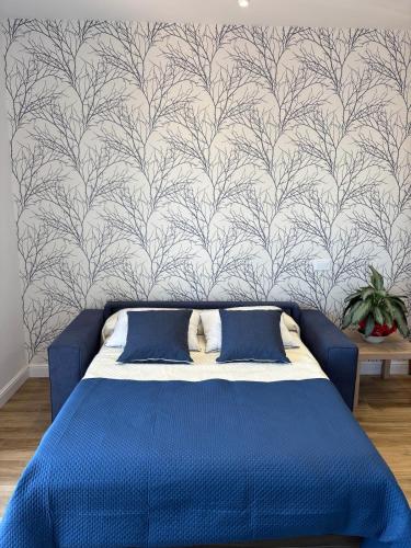 a blue bed in a room with a wallpaper at L'Abbraccio di Parthenope in Torre del Greco
