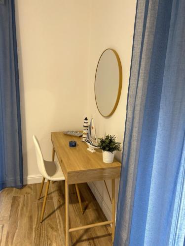 a wooden table with a mirror and a chair at L'Abbraccio di Parthenope in Torre del Greco
