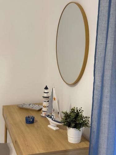 a table with a mirror and a plant on it at L'Abbraccio di Parthenope in Torre del Greco