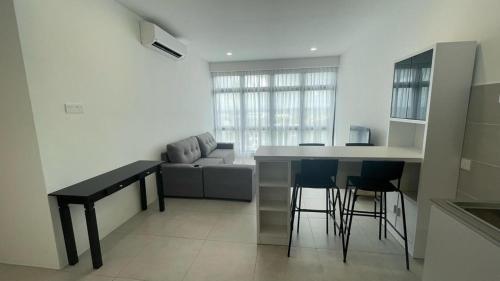 a kitchen and living room with a table and a couch at D'millenia Bangau Homestay in Kuching