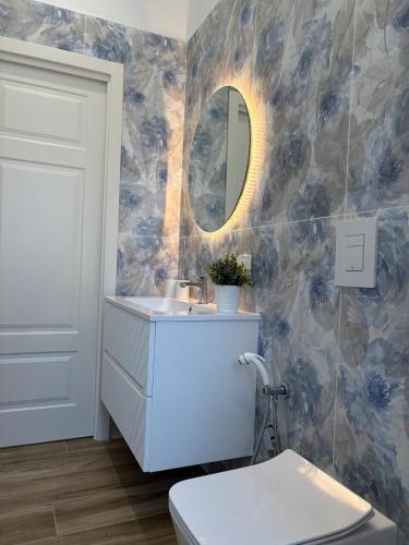 a bathroom with a toilet and a sink and a mirror at L'Abbraccio di Parthenope in Torre del Greco
