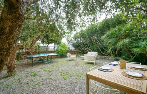 a table and chairs in a yard with a table and a table tennis racket at Nice Home In Ventimiglia in Ventimiglia