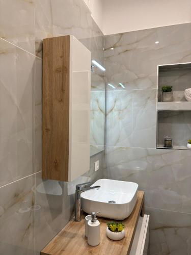 a white bathroom with a sink and a mirror at L'Abbraccio di Parthenope in Torre del Greco