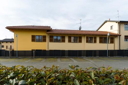 a yellow building with a fence in front of it at Monolocale Ciclamino - Cascina Da Rosa in Capiago Intimiano