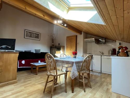 une cuisine et une salle à manger avec une table et des chaises dans l'établissement Appartement cosy avec piscine, balcon et parking - FR-1-629-124, à Samoëns