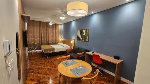 a living room with a table and a bed at Comfort and Practicality Campinas in Campinas