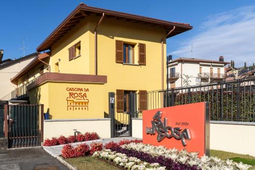 a yellow house with a sign in front of it at Monolocale Ciclamino - Cascina Da Rosa in Capiago Intimiano