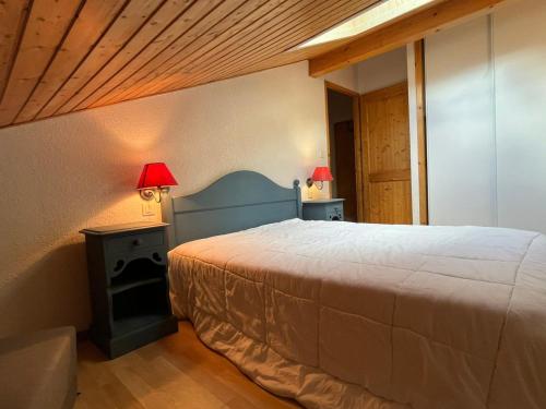 - une chambre avec un lit et deux lampes sur deux tables dans l'établissement Appartement cosy avec piscine, balcon et parking - FR-1-629-124, à Samoëns