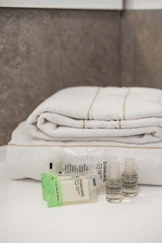a pile of towels and toothbrushes on a counter with towels at Monolocale Ciclamino - Cascina Da Rosa in Capiago Intimiano
