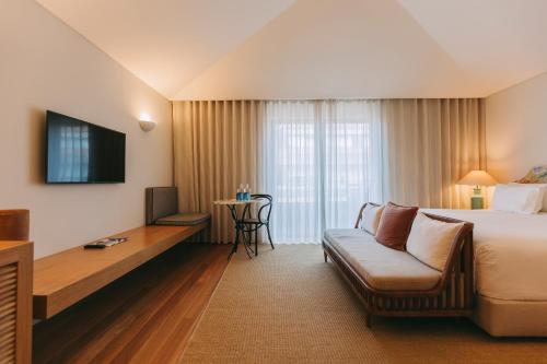 a hotel room with a bed and a couch at Torel Saboaria in Porto