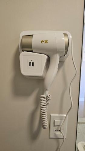 a hairdryer hanging on a wall at Comfort and Practicality Campinas in Campinas