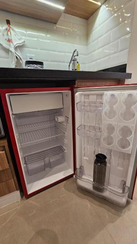 an open refrigerator in a kitchen with its door open at Comfort and Practicality Campinas in Campinas