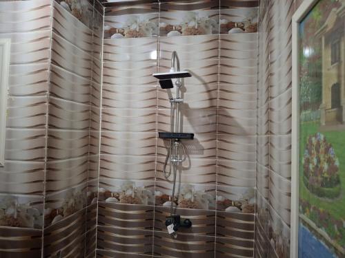 a shower in a bathroom with wooden walls at Whispers of Waves in El Delr