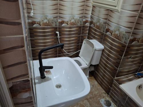 a bathroom with a white sink and a toilet at Whispers of Waves in El Delr
