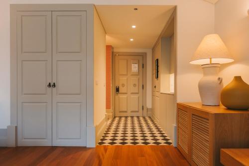 a hallway with a door and a lamp on a dresser at Torel Saboaria in Porto