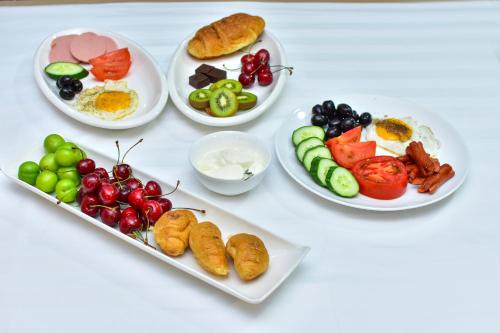 a table with plates of breakfast foods on it at Hotel Chveni Sakhli in Batumi