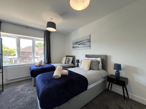 a bedroom with two beds and a window at Brand New, Immaculate 3 Bed 3 Shower room House in Cheshunt