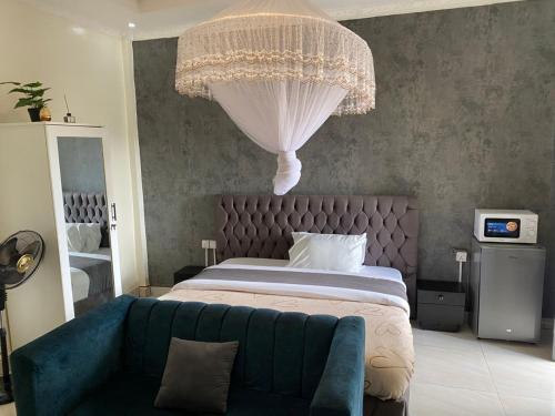 a bedroom with a large bed with a blue couch at TWIGER HOUSE by WILSON in Kigali