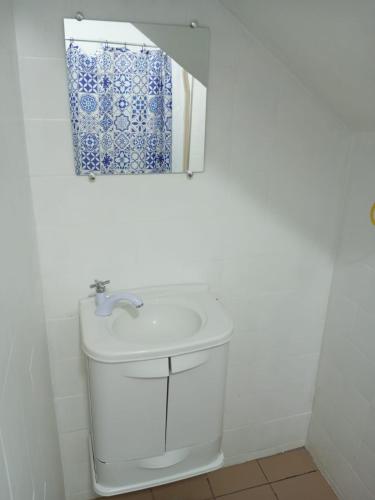 a white bathroom with a sink and a mirror at Cabo Frio Fun Hostel in Cabo Frio