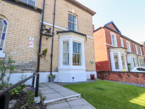 a brick house with a white front door at Mullans in Southport
