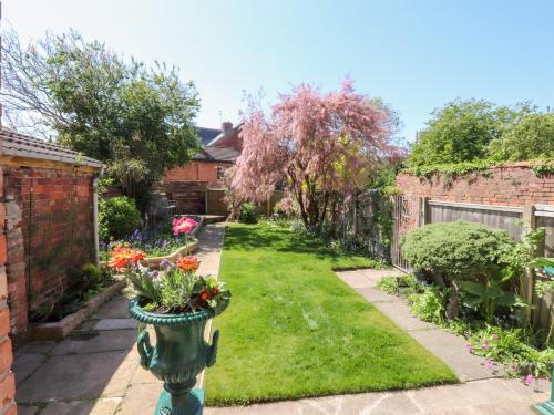 a garden with a vase with flowers in it at Mullans in Southport