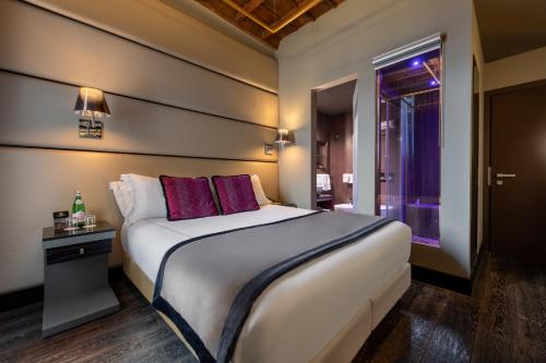 a bedroom with a large white bed and a window at Torre Argentina Relais - Residenze di Charme in Rome