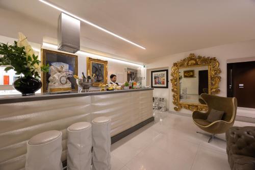 a bar in a restaurant with a woman behind the counter at Torre Argentina Relais - Residenze di Charme in Rome