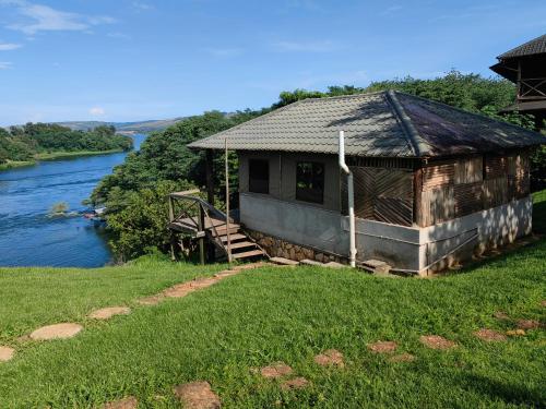 a building with a staircase next to a river at Living Waters Resort in Jinja
