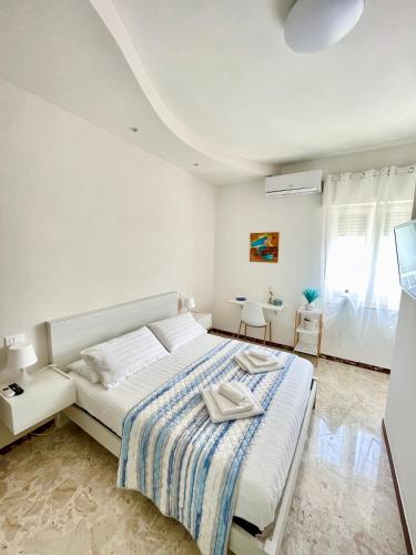 a white bedroom with a bed and a window at Acquamarina B&B Deluxe in Cariati