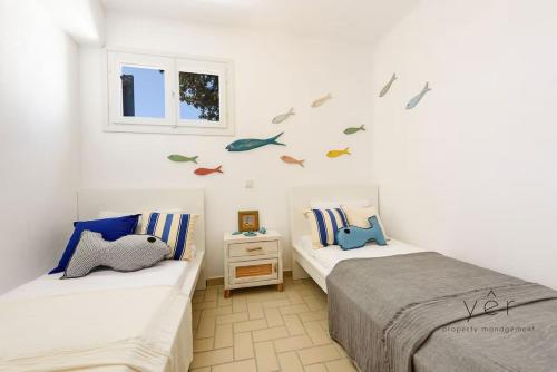 two beds in a room with birds on the wall at 6BR Villa with Private Pool, 4 Baths & Garden -PADMA in Angairiá